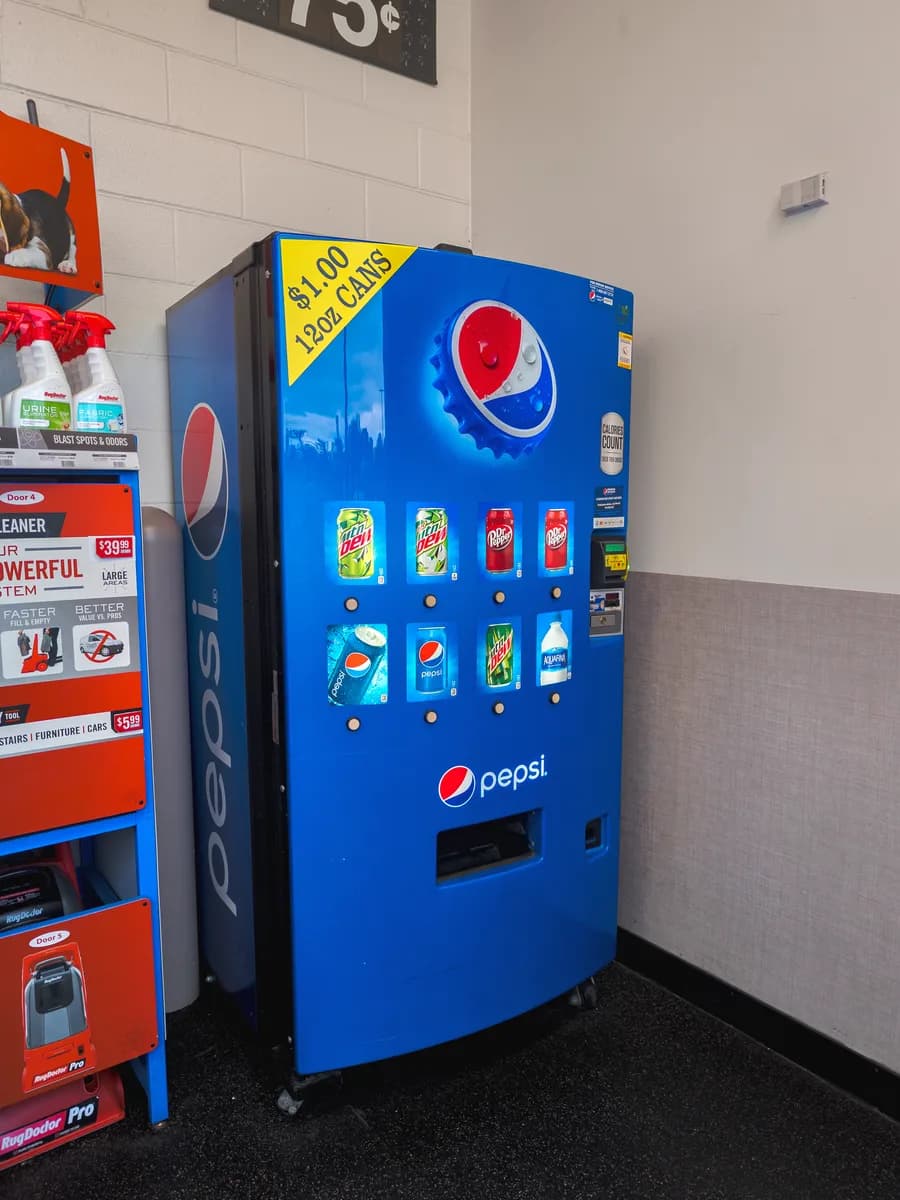 A blue Pepsi vending machine against a wall, with no display on it.