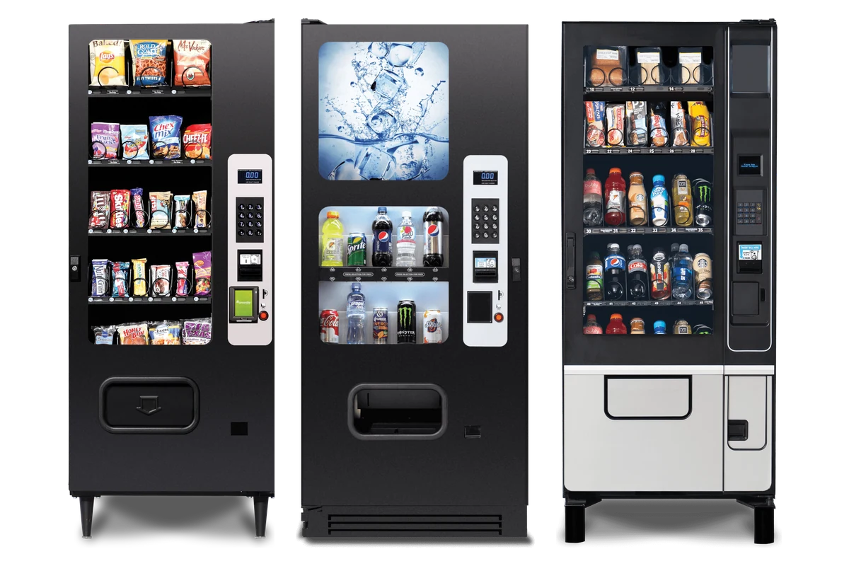 A combination drink and snack vending machine standing against an interior wall.